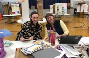 Rhianna Triolo helps Beth Kreeger with science fair at St. James Elementary School