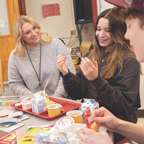 A young social worker interacts with high school students.