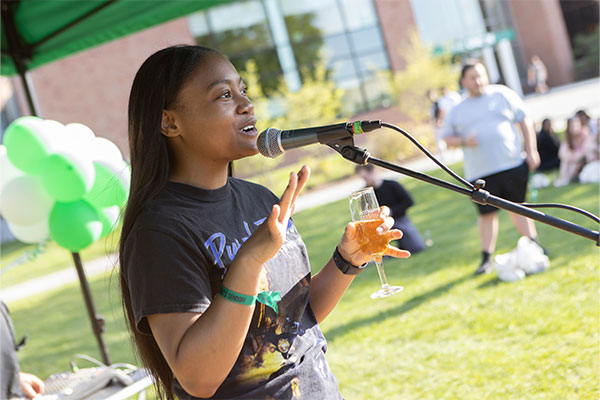 Alumna speaking into a microphone. photo