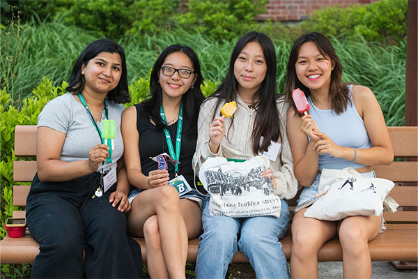 Group of students sitting on a bench eating ice cream photo