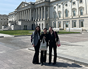 Three students standing outside the U.S. Capitol building