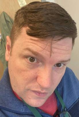 A picture of a smiling white person looking directly into the camera.