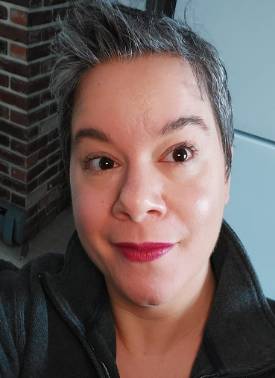 person with short hair looking into camera