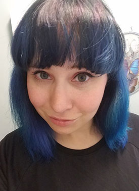 person in picture with blue hair looking into camera