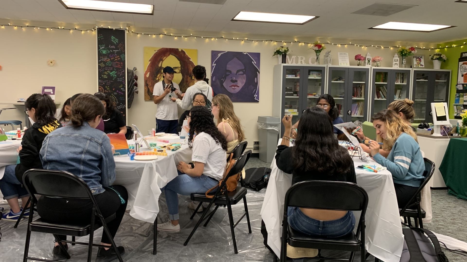 a grouping of students painting mini canvases in the MRC Lounge. photo