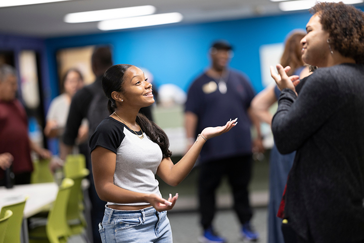 An young woman engages in conversation with a small group of people