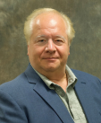 head shot of a man with a blue business jacket on looking at the camera 