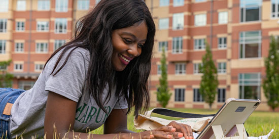 A female student outside reading a book photo