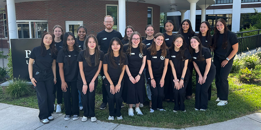 A group of 17 peer advisors standing outside the Health Sciences Building.
