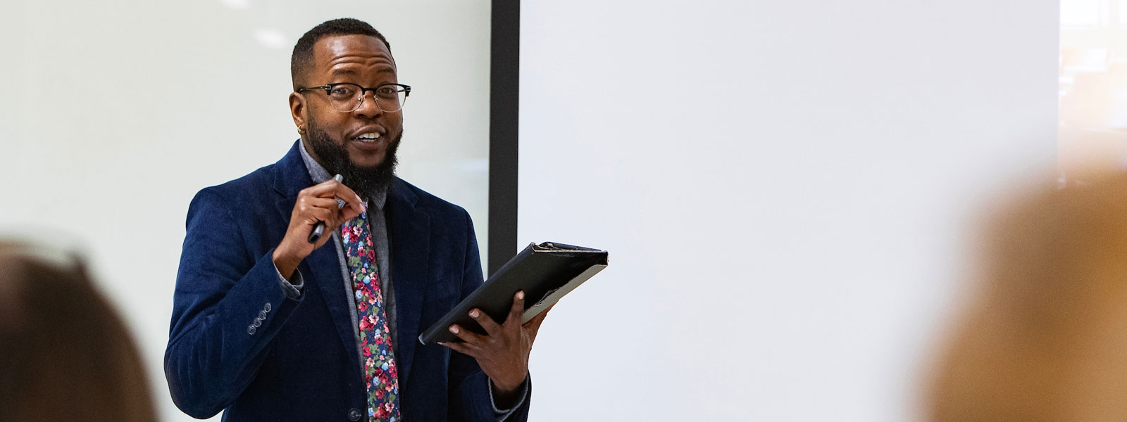 A Black male instructor in a classroom setting