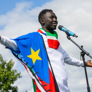 An image of a Black male student with a flag draped around his shoulders.