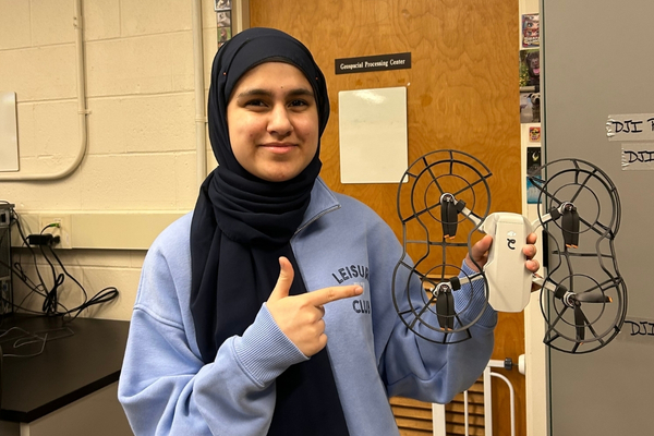 Student pointing at a drone