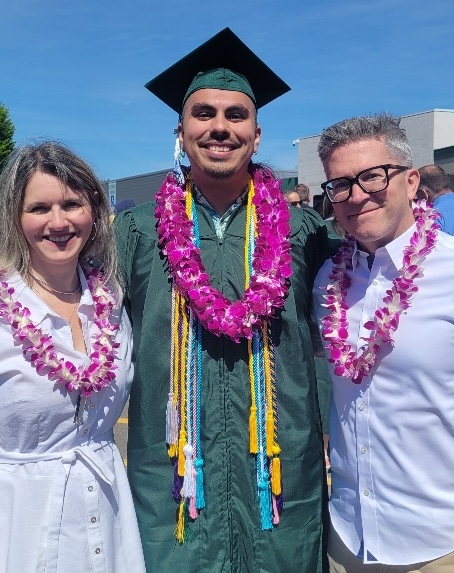 Graduating Russian major Emilio Kershner in graduation apparel, posing with Marina Zalesski and Sidney Dement