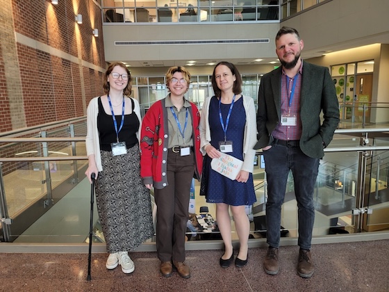 Four people standing in an atrium