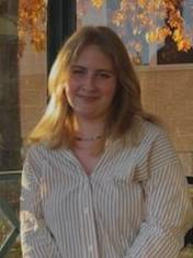 Young blonde woman wearing a white shirt sitting outside