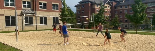 Scholars play volleyball outside of Broome Hall.