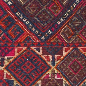 A red and white geometric pattern on a piece of fabric from the Kurdish collection