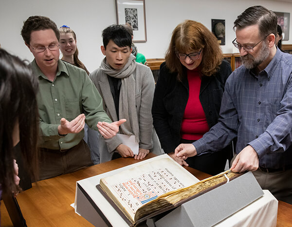 Image: Special Collections Librarian Jeremy Dibbell, left, discusses a recent acquisition, The Gradual of La Crocetta, with a group of students and faculty.