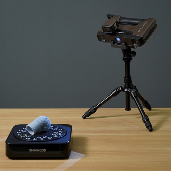 A gray object being scanned by a 3d printer