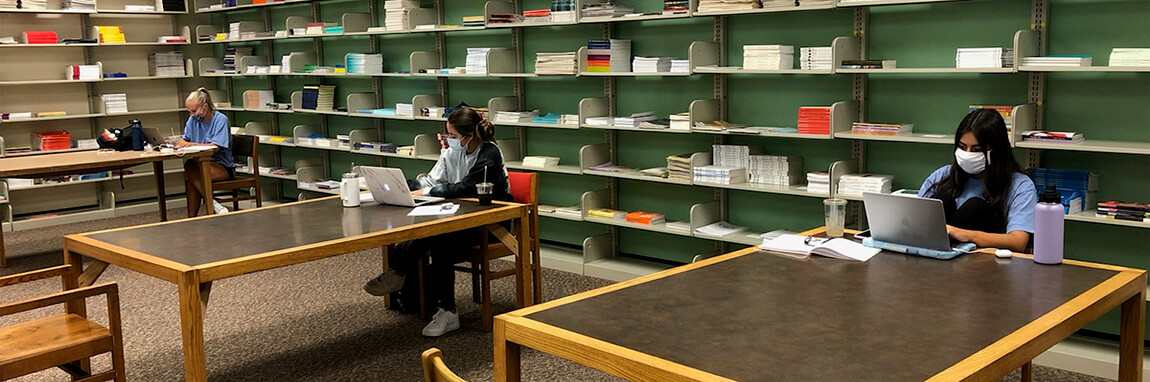 Masked student workers in a socially distanced manner in the Libraries