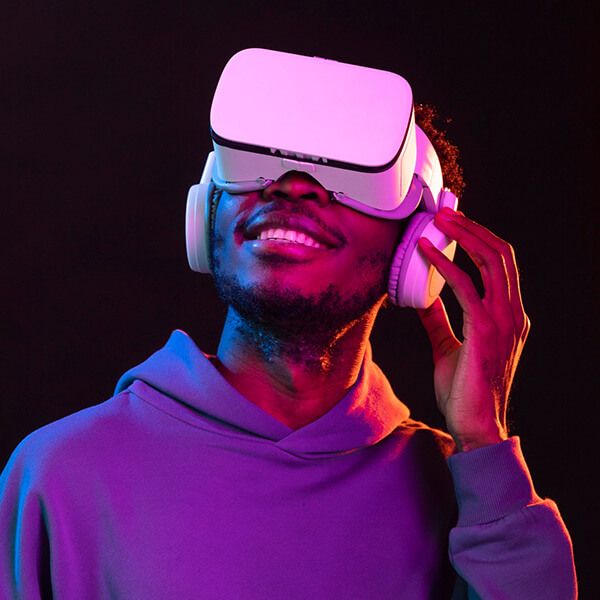 A man with beard wears a VR headset and smiles, looking up