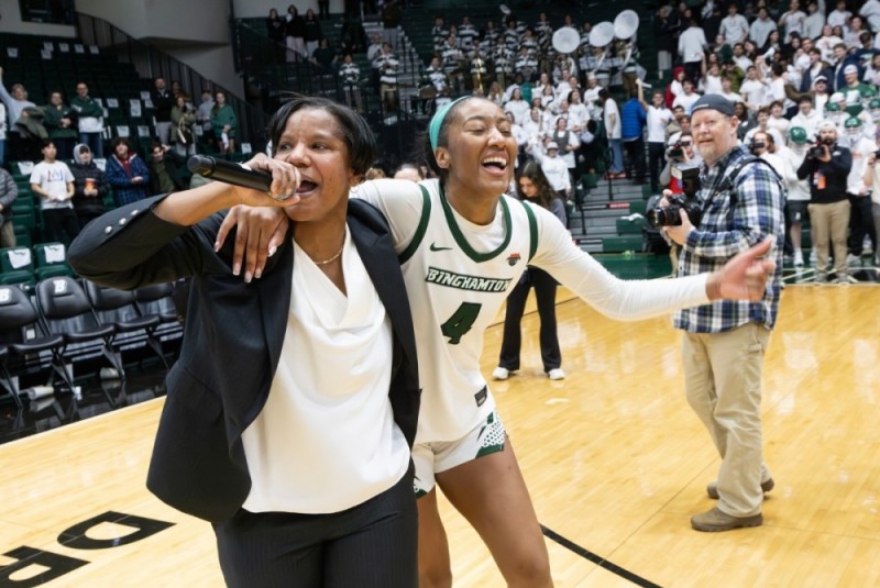 Basketball Coach Mary Grimes on the microphone following a victory
