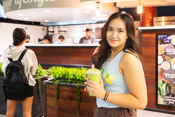 Student, Nicole Bunke, holds a Green to Go drink from Shake Smart in the MarketPlace
