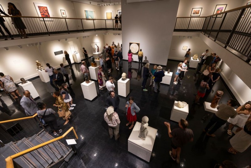 People browse various sculptures at a museum exhibit.