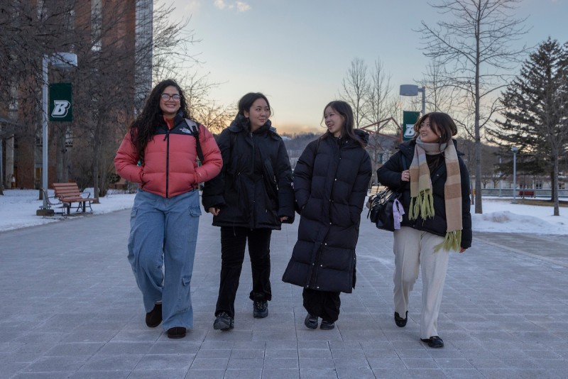 A group of students walk along the Lois B. DeFleur Walkway during a very cold start to the Spring 2025 semester, January 21, 2025.