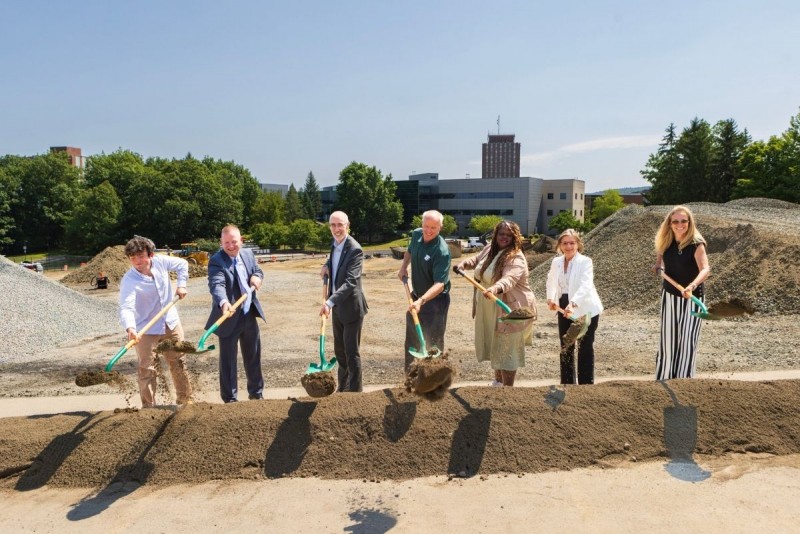 Various members from the campus and the local government hold shovels outside to break ground for a new Lecture Hall building.