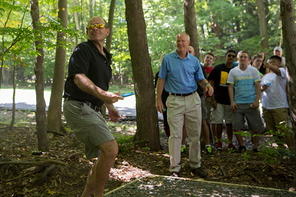 People playing disc golf on campus