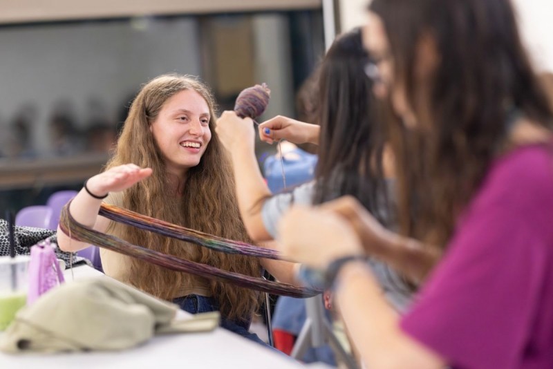 A student pulls yarn at the knitting student organization 