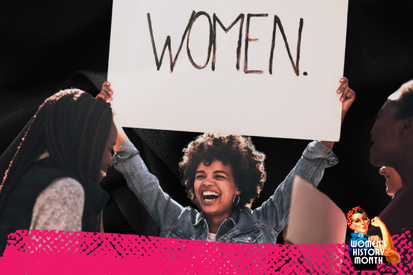 A woman of color holds a sign above her head that says, 