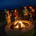 Five students enjoying s'mores over the Mountainview fire pit in 2018