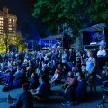 A crowd sits to watch a projection