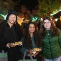 Three friends smile with a couple of plates of food at the 2022 Binghamton Block Party