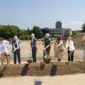 Various members from the campus and the local government hold shovels outside to break ground for a new Lecture Hall building.