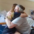 A student embraces their parent in their room during Move-in.