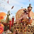 A man riding on a large Turkey float in the Macy's Day Parade.