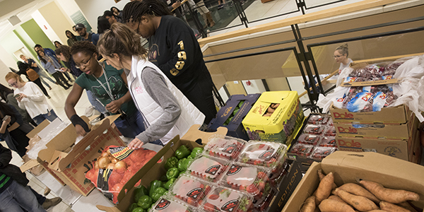 Members of the Graduate Student Organization at Binghamton University distribute free produce to students.