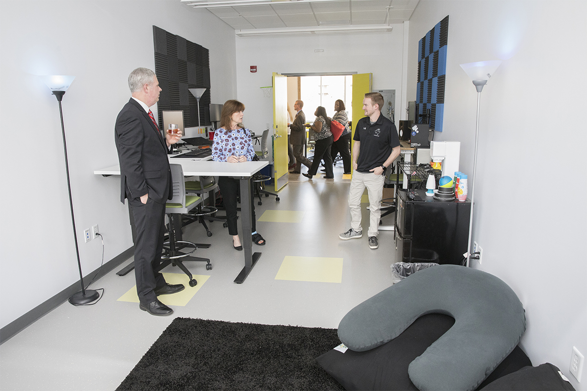 Broome County Executive Jason Garnar and Colleen Wagner speak with Trevor Barney of the startup company SouthSixty at the space Barney's company is leasing at the Koffman Southern Tier Incubator.