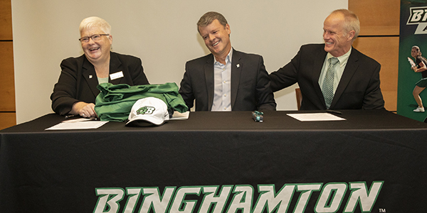 Michael Lane, center, shares a laugh with Sheila Doyle and President Harvey Stenger following a gift-signing in support of athletics.