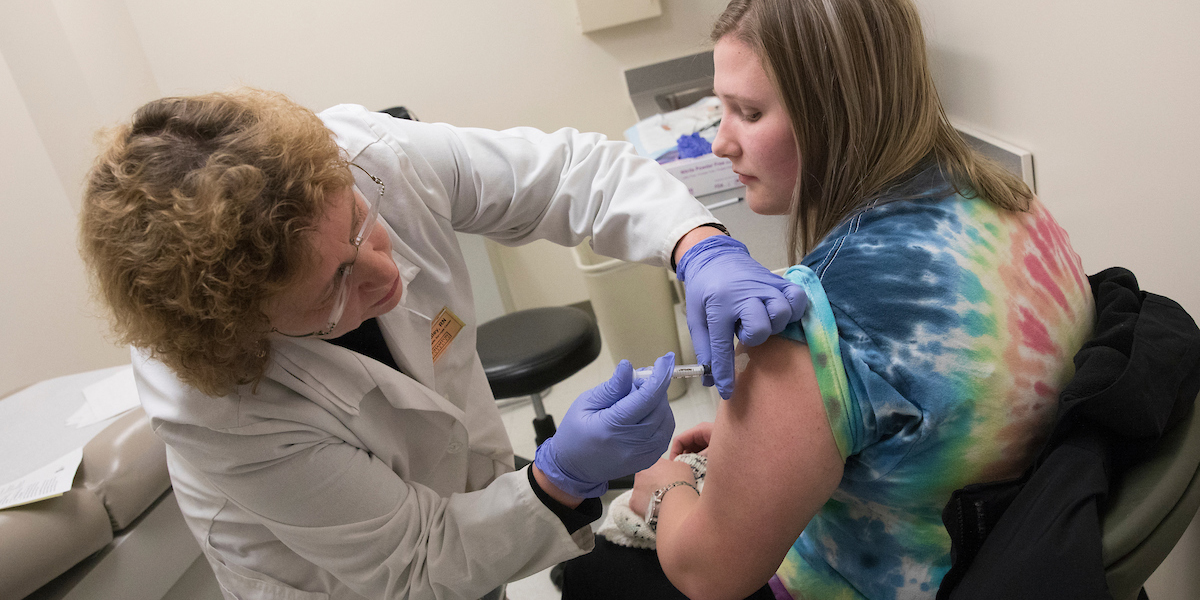 Lynne Radley, a registered nurse at Decker Student Health Services Center, administers a flu shot to a student during a vaccination clinic.