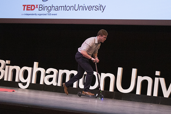 Binghamton University junior Jonathan Caputo rides onto the TEDxBinghamtonUniversity stage on a scooter before giving his 