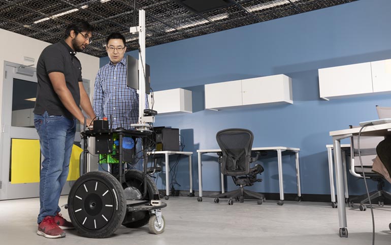 Assistant Professor Shiqi Zhang, right, runs the Computer Science Department's Autonomous Intelligent Robotics Lab at the Watson School. Pictured with Zhang is PhD student Kishan Chandan.