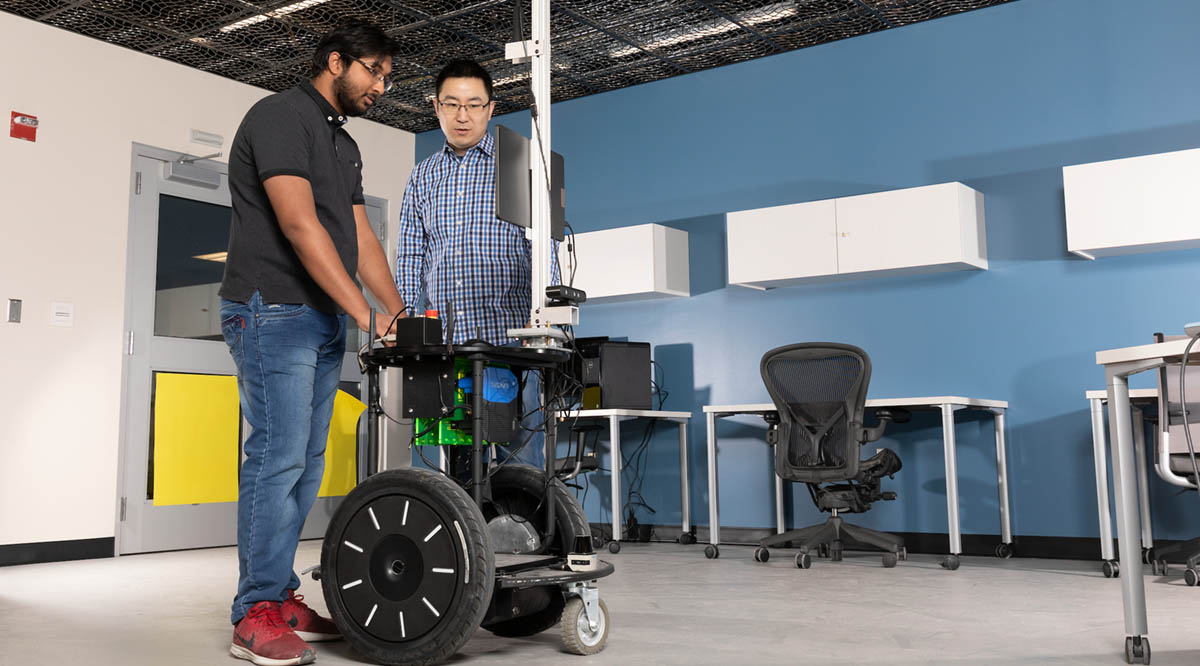 Assistant Professor Shiqi Zhang works with PhD student Kishan Chandan at Zhang’s Autonomous Intelligent Robotics Lab.