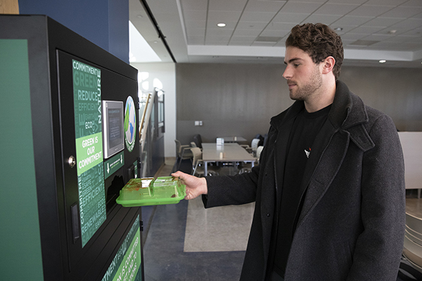 Sophomore Michael Kucza uses the new OZZI system that allows patrons of Binghamton University dining halls to use reusable food containers that can be returned to a vending machine after use.