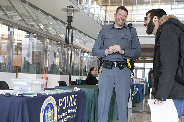 University Police Officer Allen Saxby shares a laugh with Master of Public Administration student Joe Seif during the Community Connections Information Fair held at the University Downtown Center on Feb. 18.