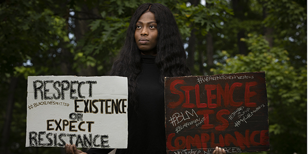 Veronica Agyapomaa, a graduate student in the College of Community and Public Affairs’ Masters of Social Work program, poses with posters she carried during the peaceful Black Lives Matter protest that ended at Recreation Park on Sunday, June 3.