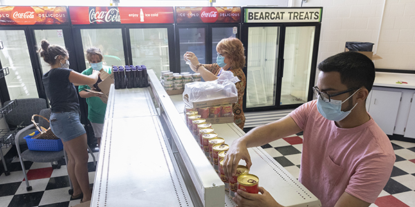 The Binghamton University Food Pantry moved to the College-in-the-Woods Dining Center in the Iroquois Commons in August. The pantry is a temporary, judgment-free respite for students facing hard times, such as running short of money for the month, or facing emergency situations. Pictured here, Jason Ocampo, computer science major, right; Marsha Roe, administrative assistant, and Linda Salomons, parent, family and events coordinator, both from the Office of the Dean of Students; and Maddie Petherick, graduate assistant.